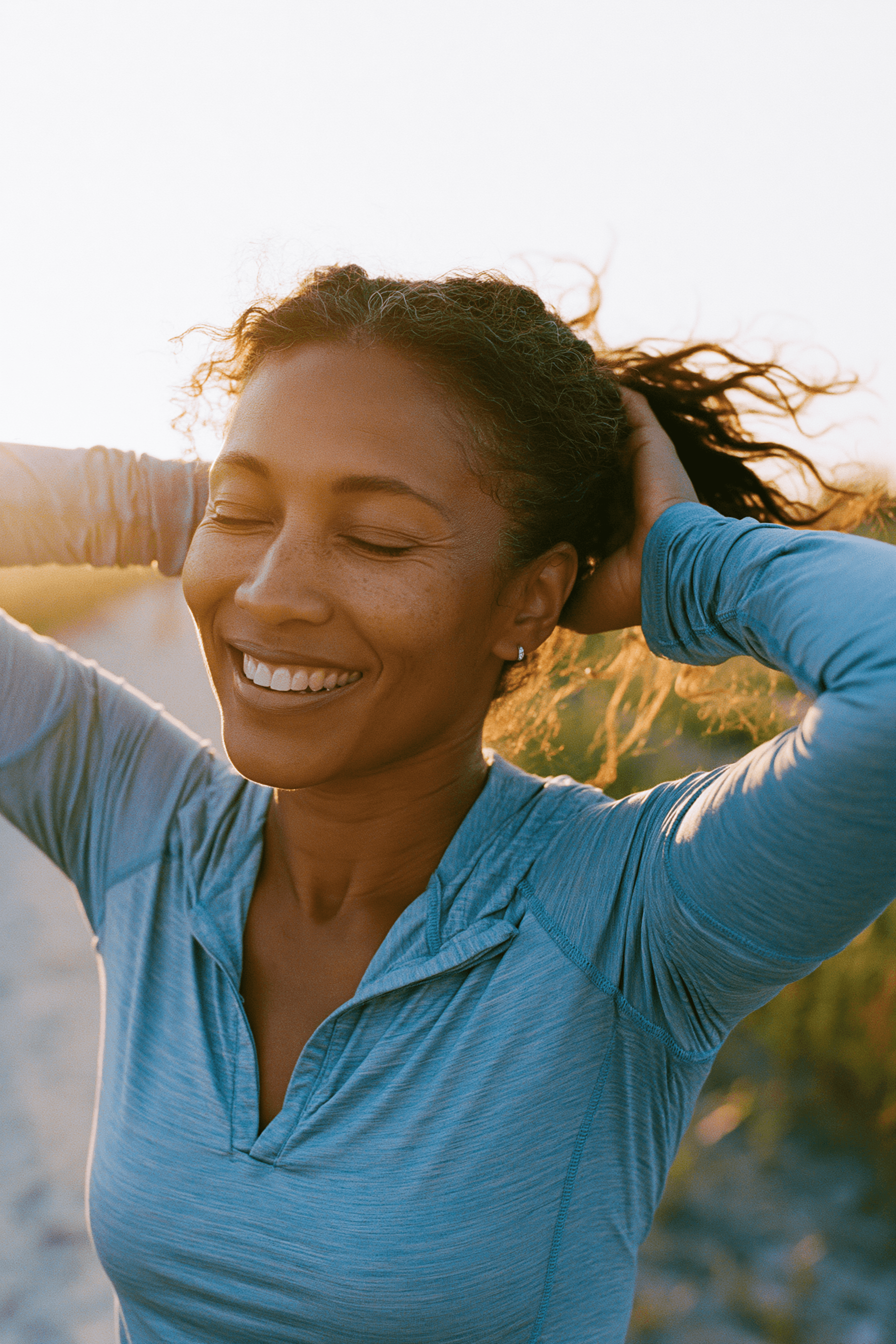Teledris patient tying her hair back, feeling confident after a workout