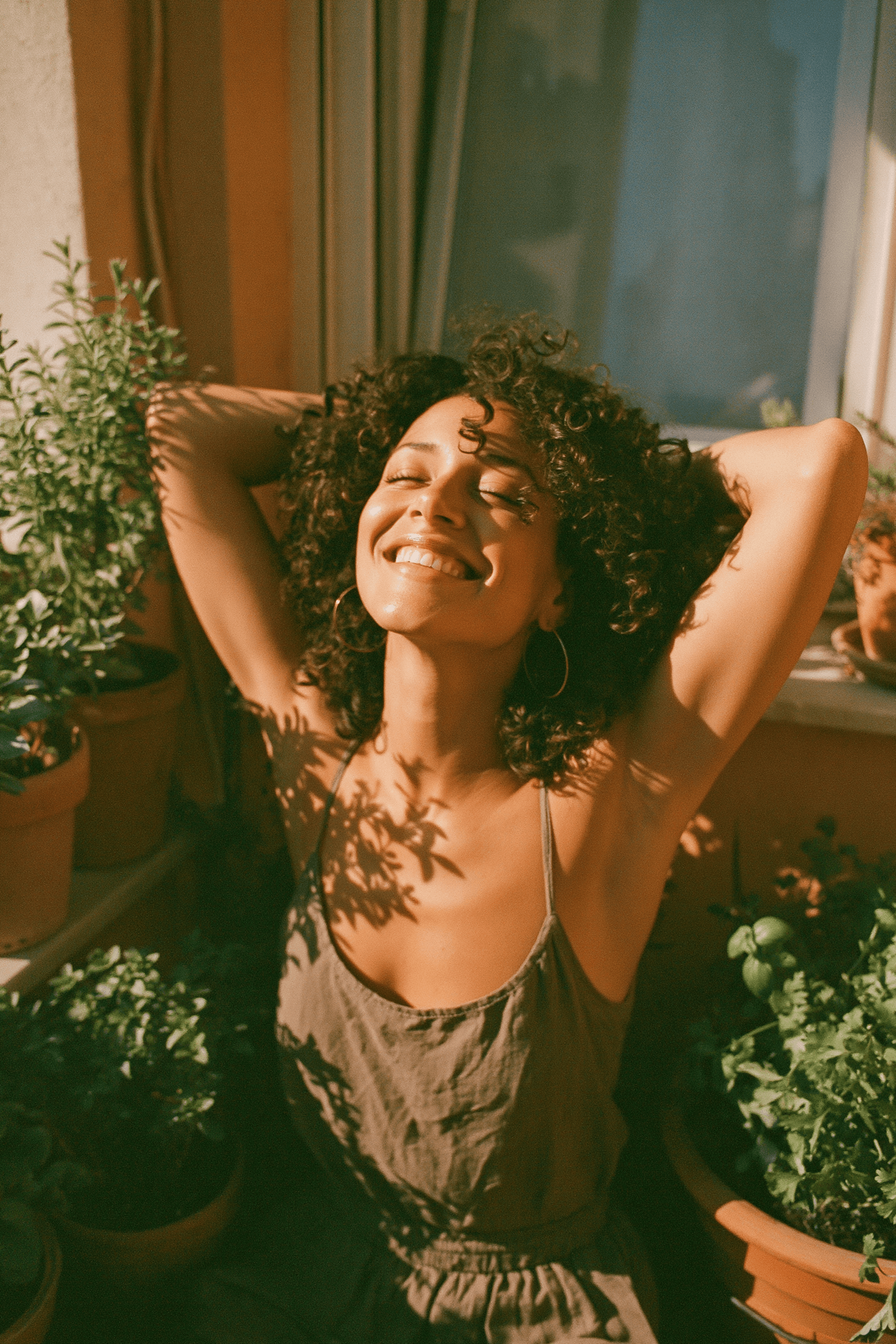 Teledris patient stretching joyfully on a sunlit balcony with potted herbs